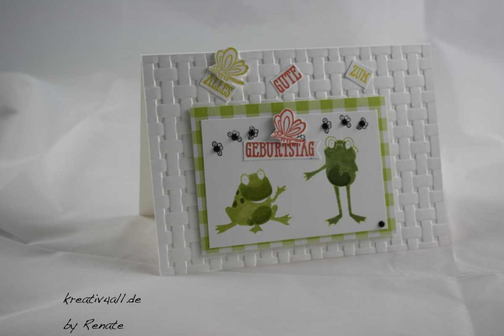 Ein sitzender und ein stehender Frosch, die sich ansehen und zum Geburtstag gratulieren, mit 6 schwarzen Brummern und zwei Libellen.